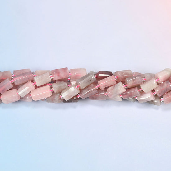 Madagascar multi color rose quartz faceted tube beads crossing the frame in a shallow wave of overlapping strands.