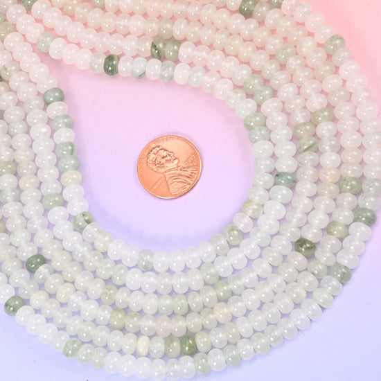 Natural Tianshan Jade smooth rondelle beads in soft milky white with scattered sage-green accents, finished with a smooth, polished surface for a classic, timeless look.