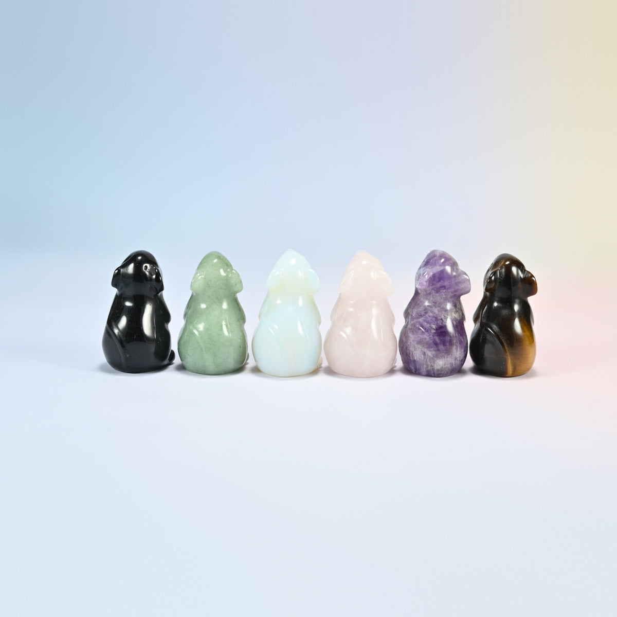 Back view of six mouse crystal carvings in black, green, white, pink, purple and brown
