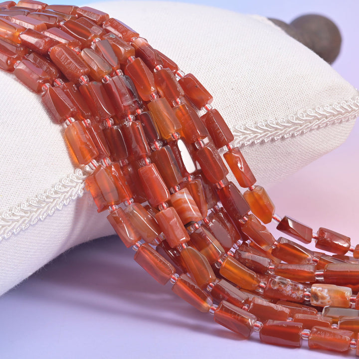 Natural Carnelian faceted tube beads in warm orange-red hues.