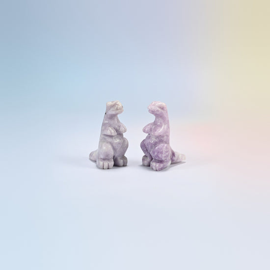 Two lepidolite T-Rex dinosaur crystal carvings, 2 inch, lilac natural stone with purple flecks