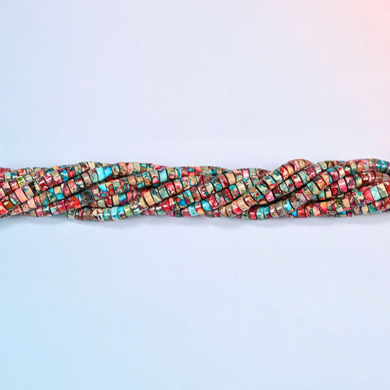 Strands of dyed pink blue sea sediment jasper heishi disc beads 2x4mm twisted together in a horizontal row