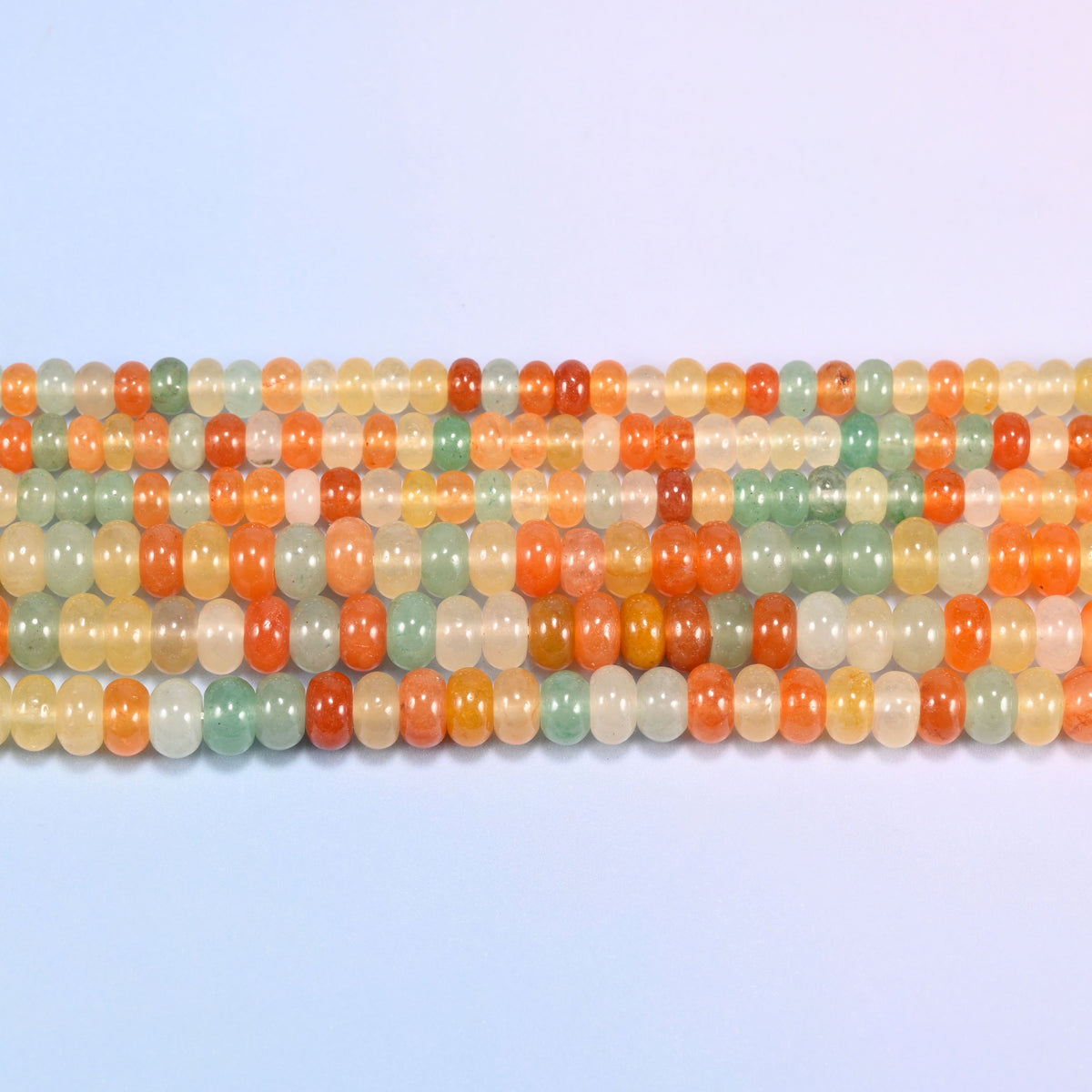 Gold Silk Jade gemstone rondelle beads in straight rows, showing the flat disc profile and centre drilling