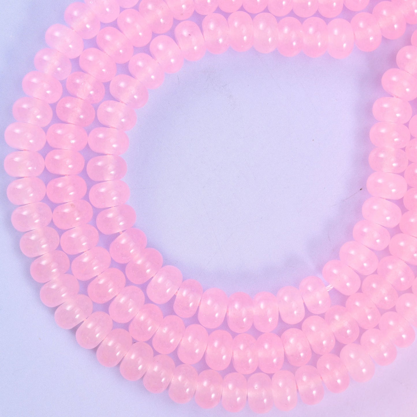 Pink Dyed Jade smooth rondelle beads in a soft blush pink, finished with a smooth, polished surface for a classic, timeless look.