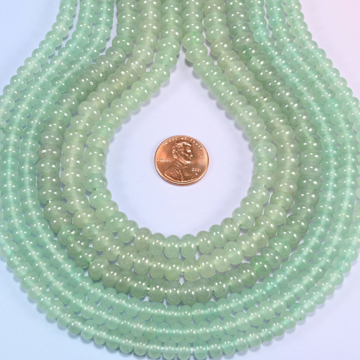 Green Aventurine gemstone rondelle beads in a teardrop coil, smooth light green discs stacked close together