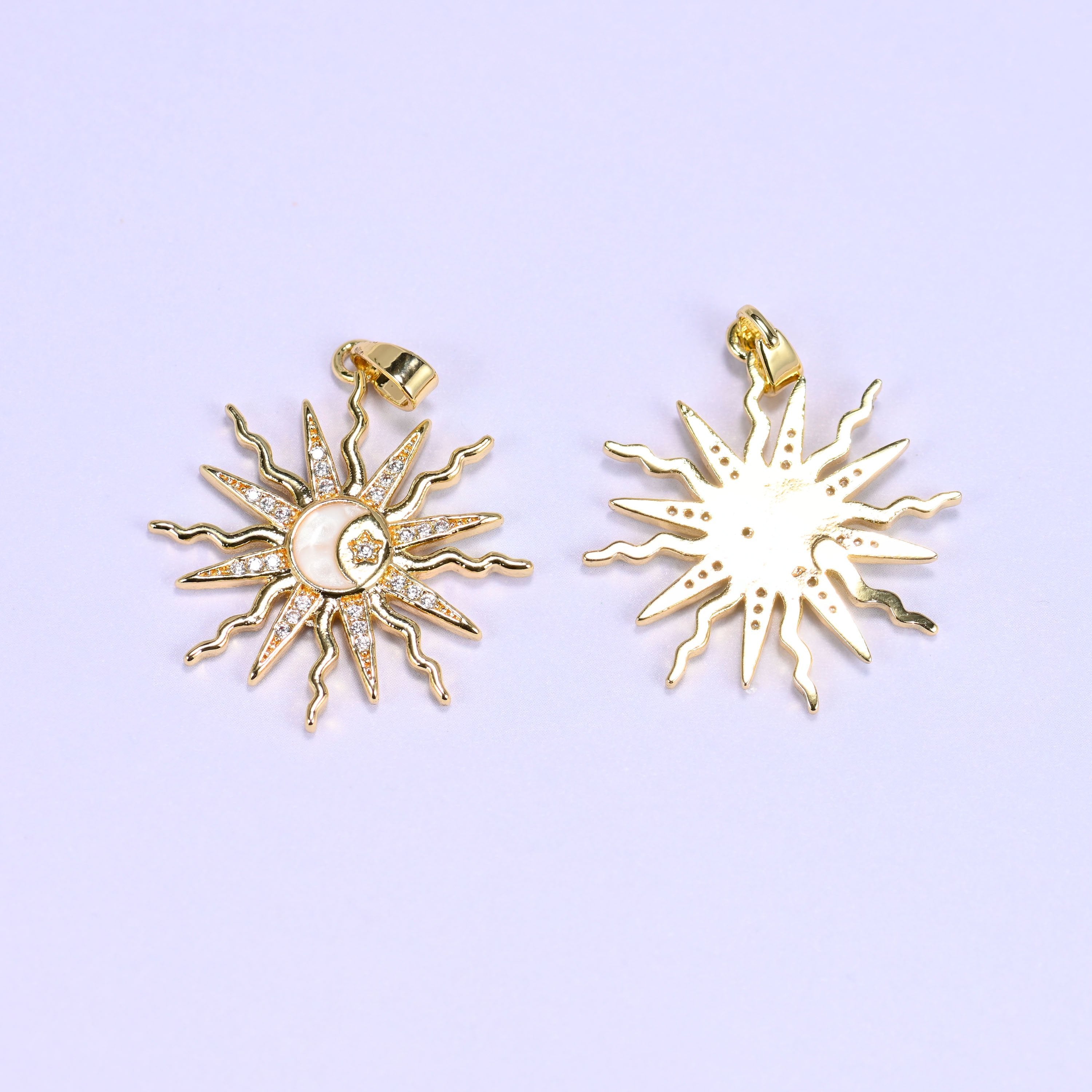 Sun charm with wavy zircon-paved rays framing an enamel moon and star center