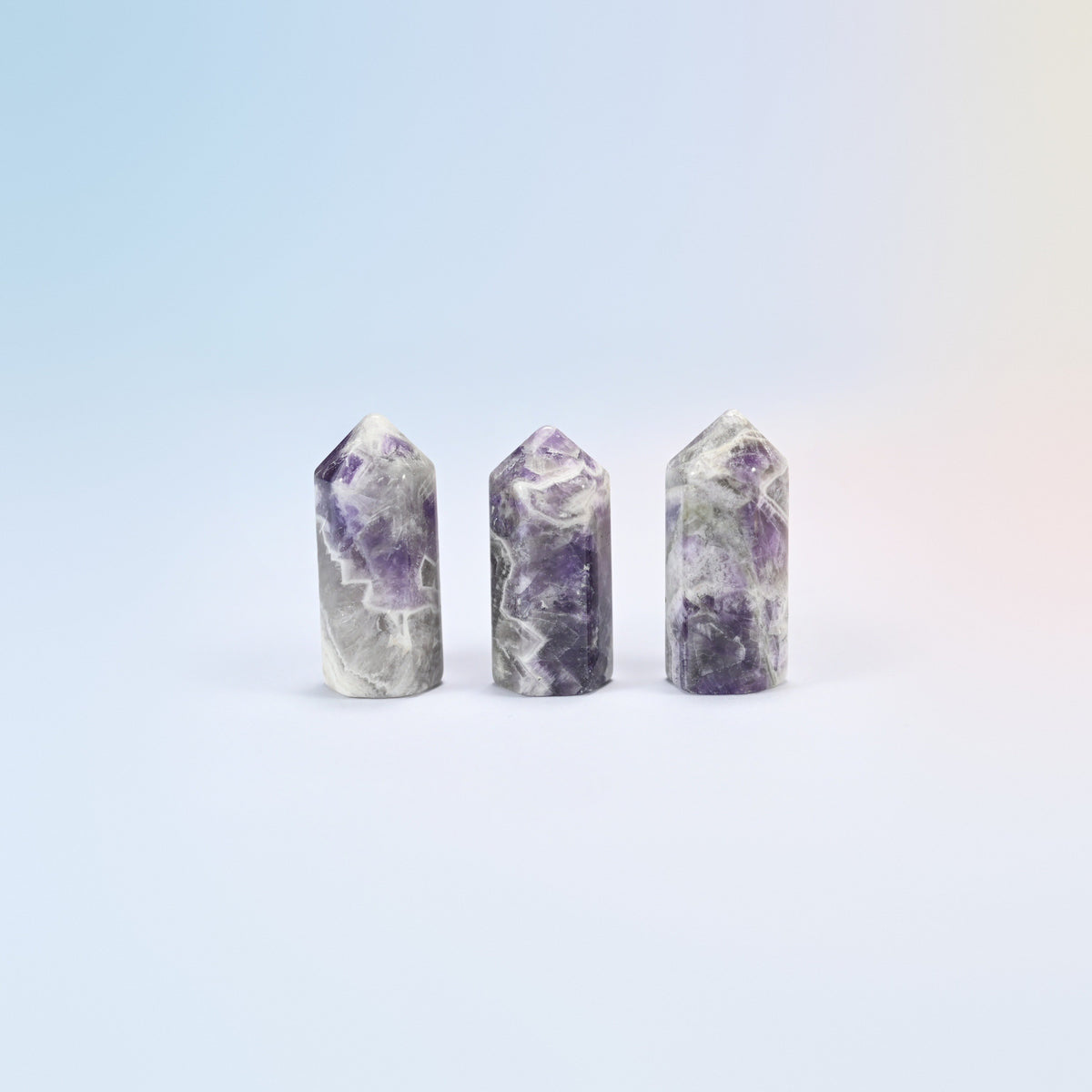Three natural amethyst small hexagon crystal points, purple and white banded
