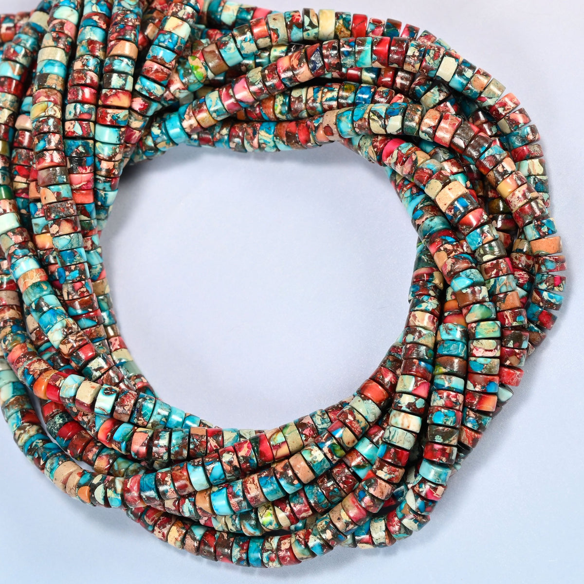 Dyed red blue sea sediment jasper heishi disc beads 2x4mm coiled into overlapping loops, whole strands of turquoise, brick red and cream discs
