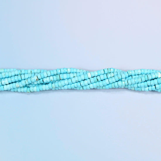 Strands of dyed blue howlite faceted heishi disc beads twisted together in a horizontal row