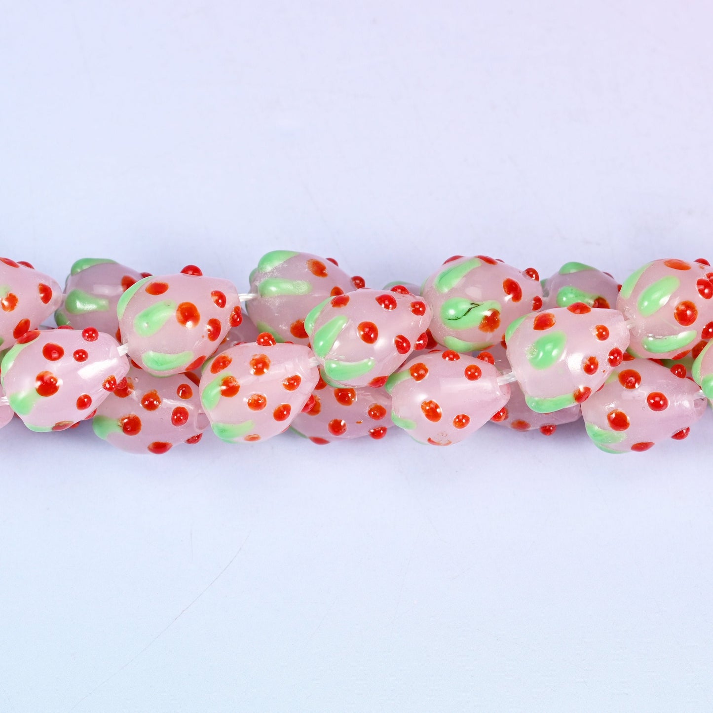 Man-made glass strawberry beads in pink, red and green