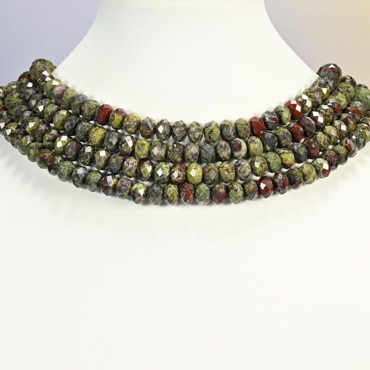 Dragon bloodstone faceted rondelle strands arranged as a layered collar on a white display bust, green and red beads across the neck