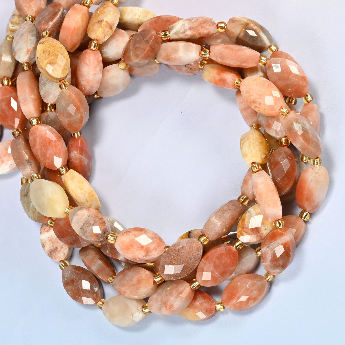 Red crazy agate faceted flat oval beads coiled into overlapping loops, whole strands of warm banded stone