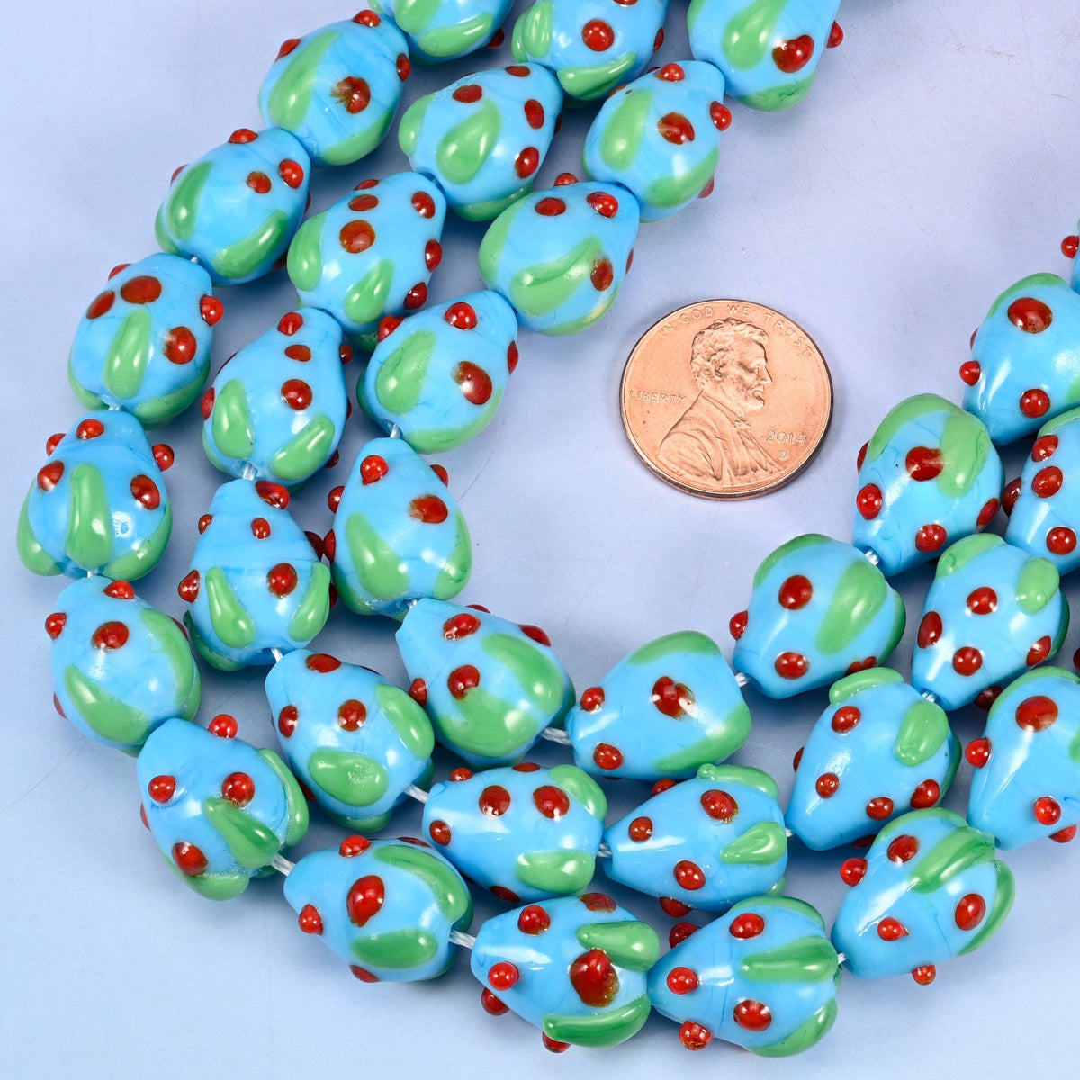 Strawberry with a green glass leaf cap cut glass beads