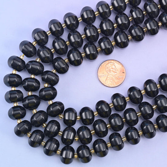 Obsidian pumpkin rondelle strands looped around a US penny to show the 12x8mm bead scale