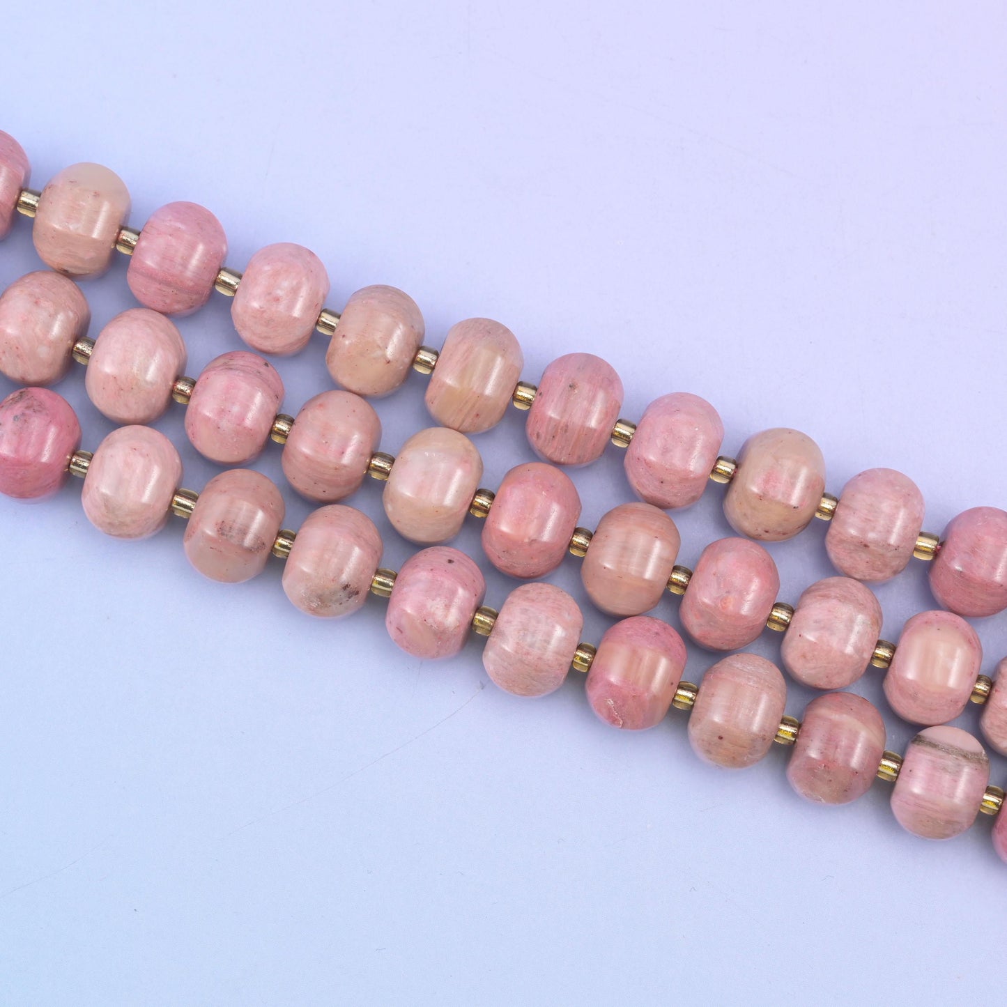 Pink rhodonite beads in warm mauve-pink with soft tonal shading