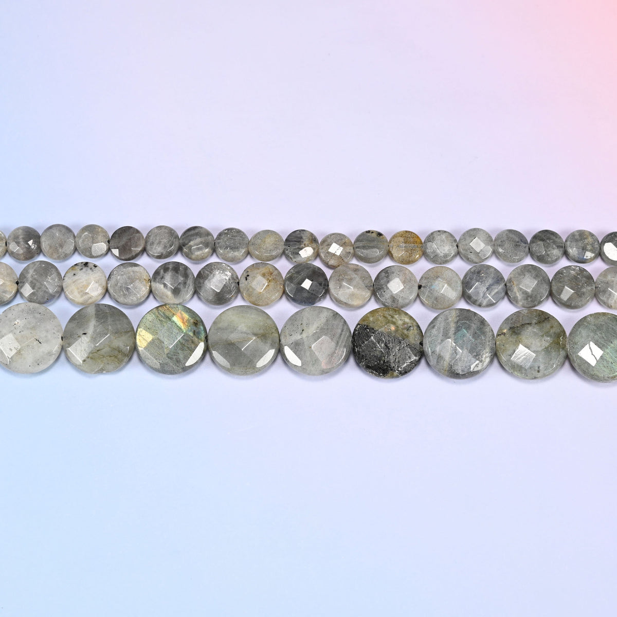 Gray Labradorite faceted coin beads in horizontal rows, the discs lying face-on along each strand