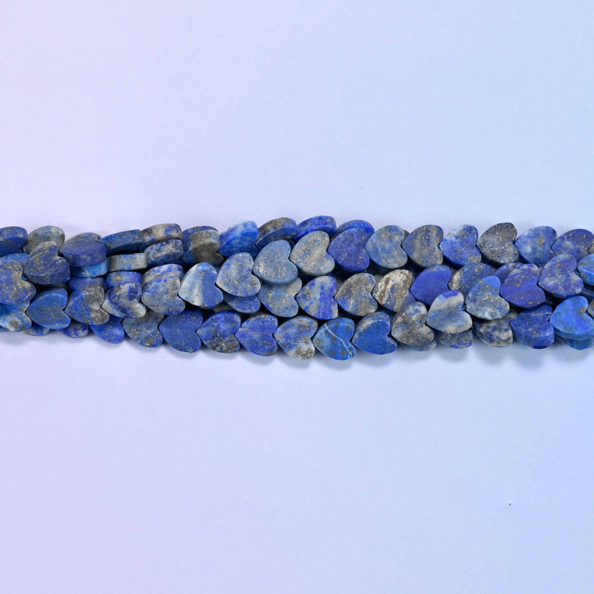 Matte lapis lazuli flat heart beads in deep denim blue marbled with grey and chalk white, finished matte so the color reads soft and powdery.