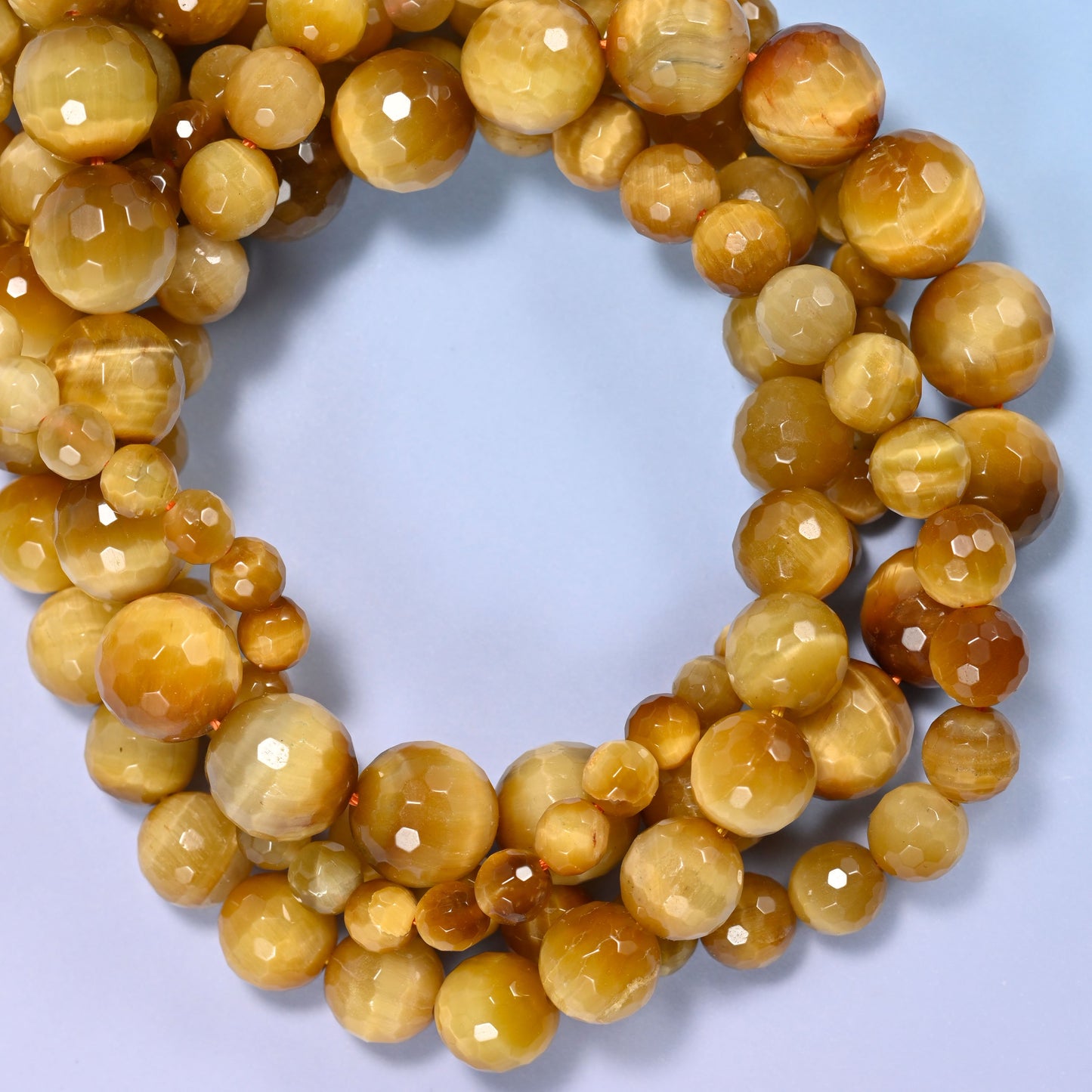 Golden brown gold tiger eye faceted round beads in 6mm, 8mm, 10mm, and 12mm, 15-inch strand, for jewelry making.