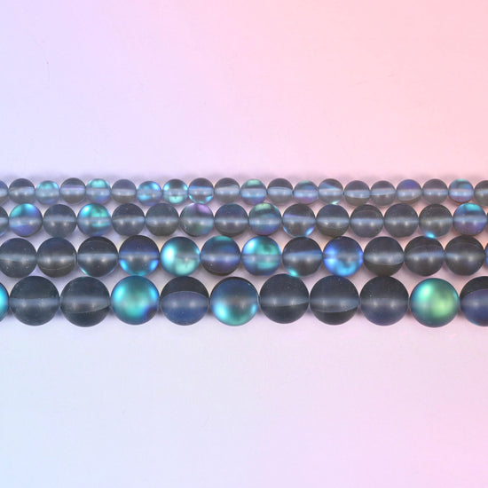 Matte glass beads in frosted smoke grey with a blue-and-green aurora shimmer
