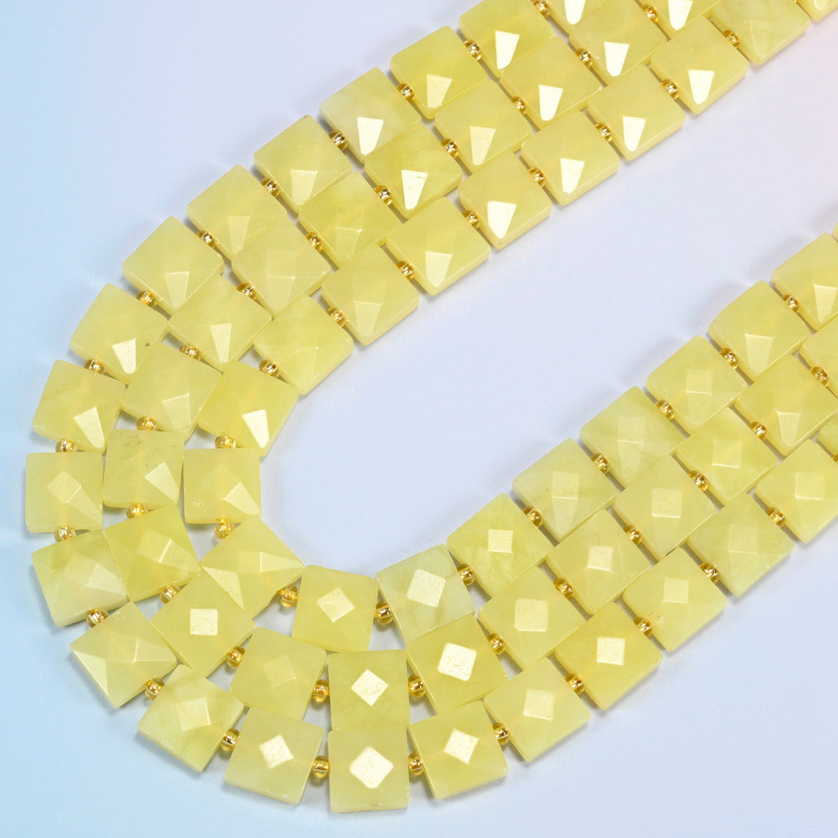 Lemon Jade faceted flat square beads in several strands curved into a wide U, soft light lemon yellow stone
