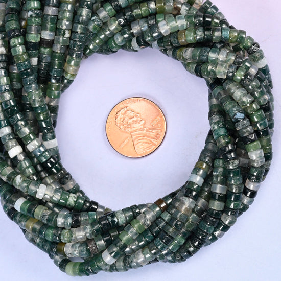 Moss Agate smooth heishi disc bead strands coiled around a US penny for size reference