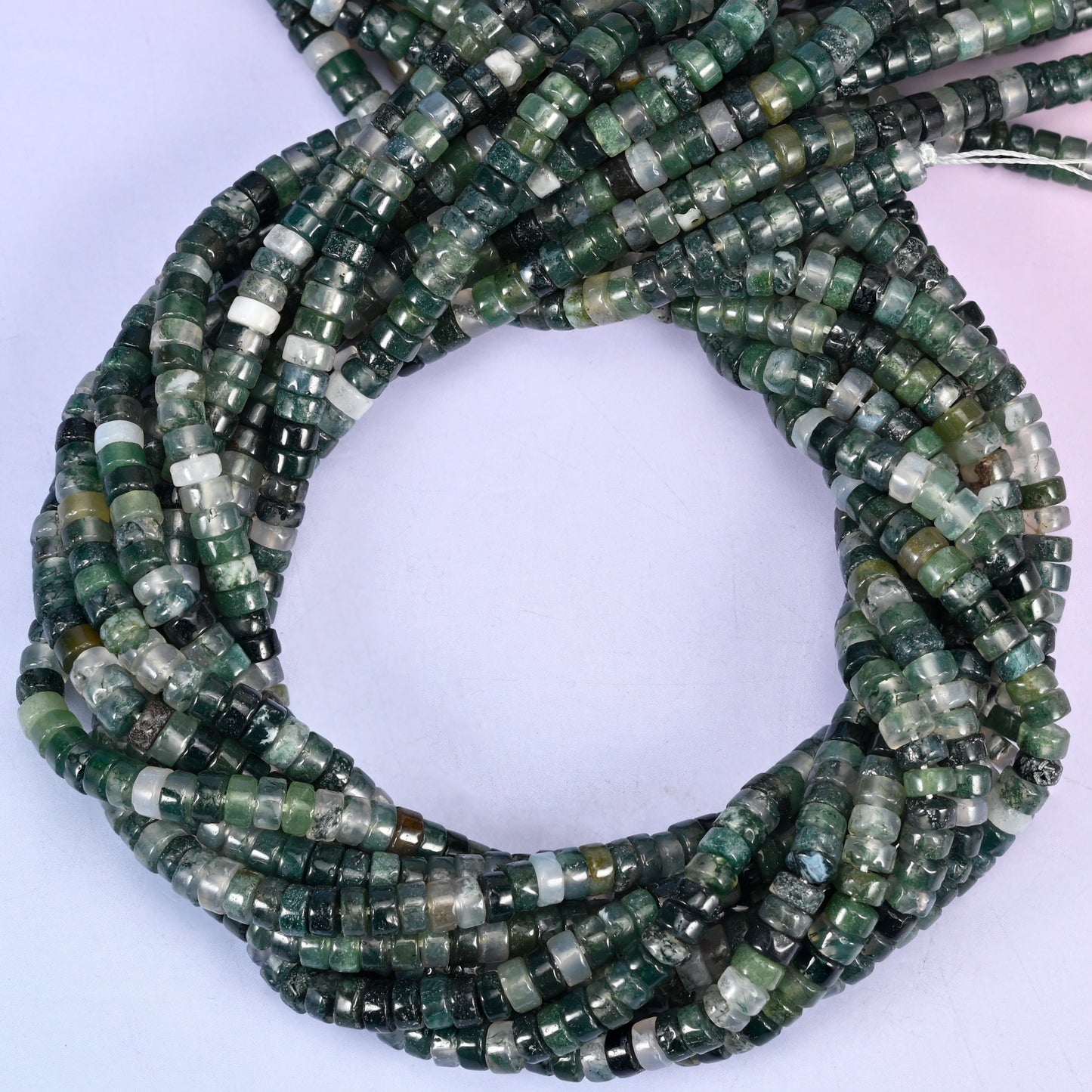 Moss Agate smooth heishi disc beads, close view of the coiled strands showing deep green with translucent white inclusions