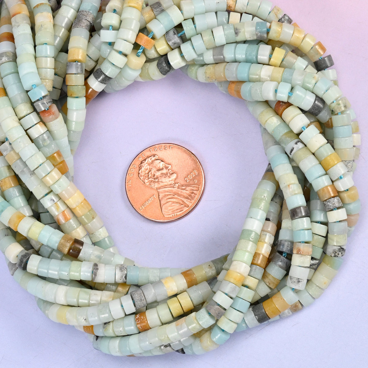 Multi-Color Amazonite smooth heishi disc bead strands coiled around a US penny for size reference