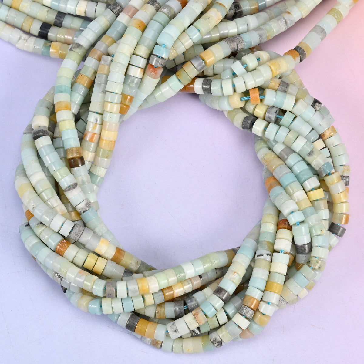 Multi-Color Amazonite smooth heishi disc beads, close view of the coiled strands mixing sea green, cream, amber and grey
