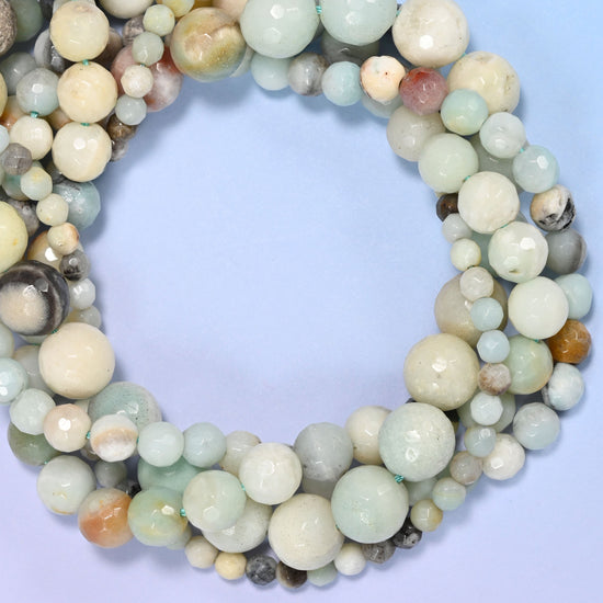 Multicolor Amazonite faceted round beads, close view of the coiled strands mixing seafoam green, cream and grey