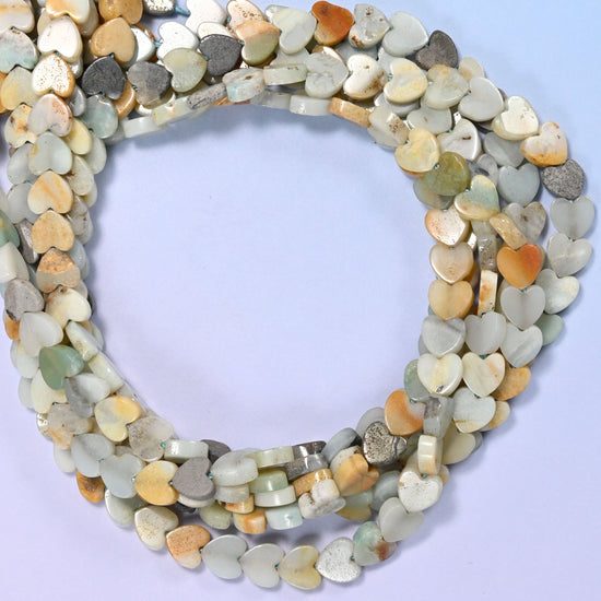 Multicolor Amazonite flat heart beads, close view of the coiled strands mixing seafoam green, cream, tan and grey