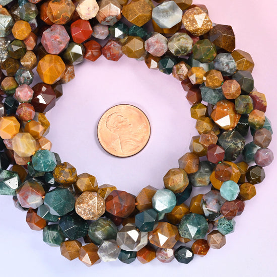Ocean agate faceted diamond star cut bead strands coiled around a US penny for size reference