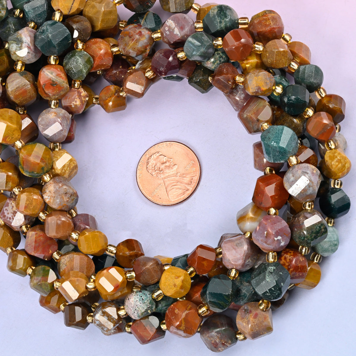 Ocean Agate faceted spiral twist bead strands coiled around a US penny for size reference