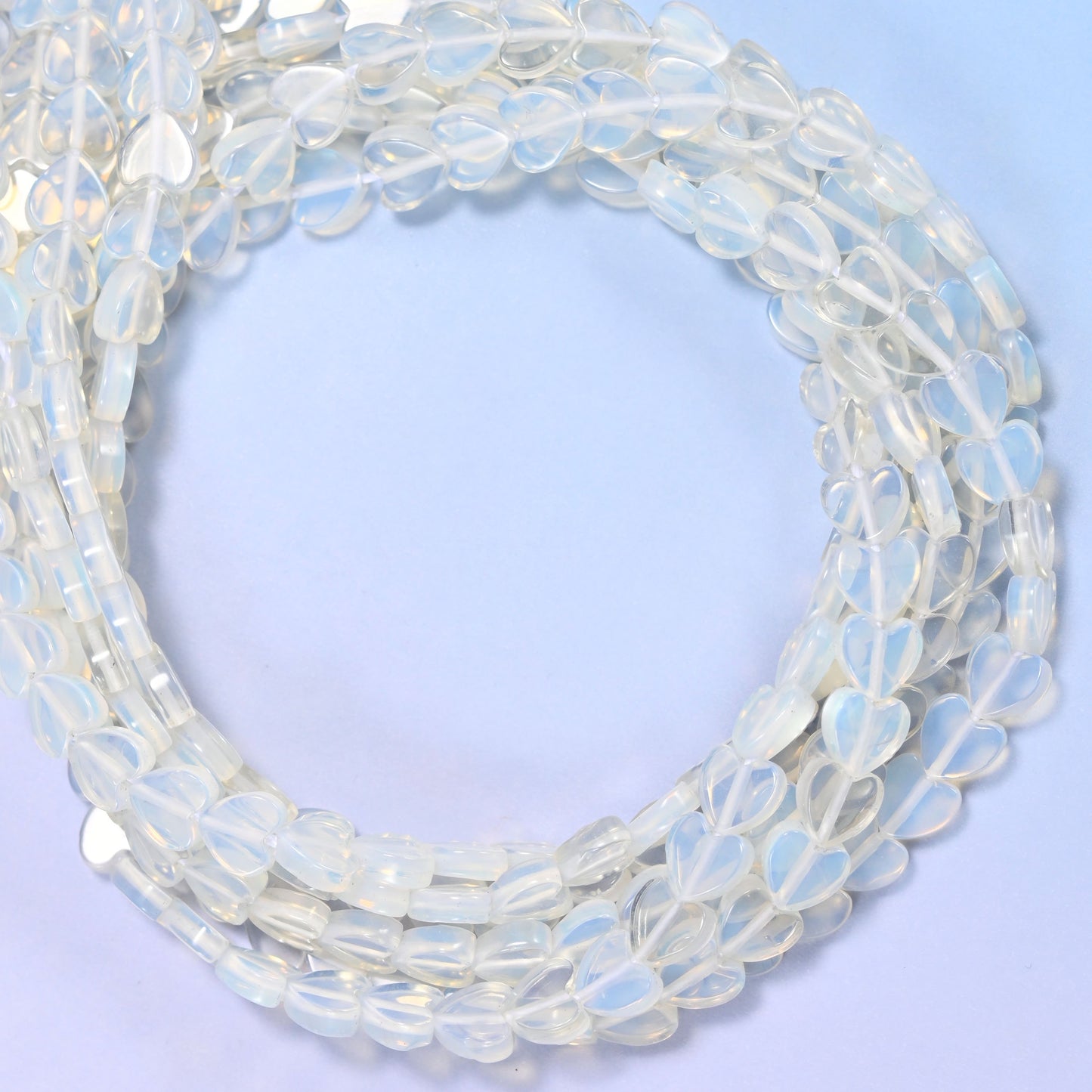 Opalite flat heart beads, close view of the coiled strands of milky translucent white hearts