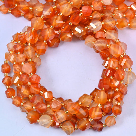 Orange Carnelian faceted spiral twist beads, close view of the coiled strands showing warm orange with lighter banding