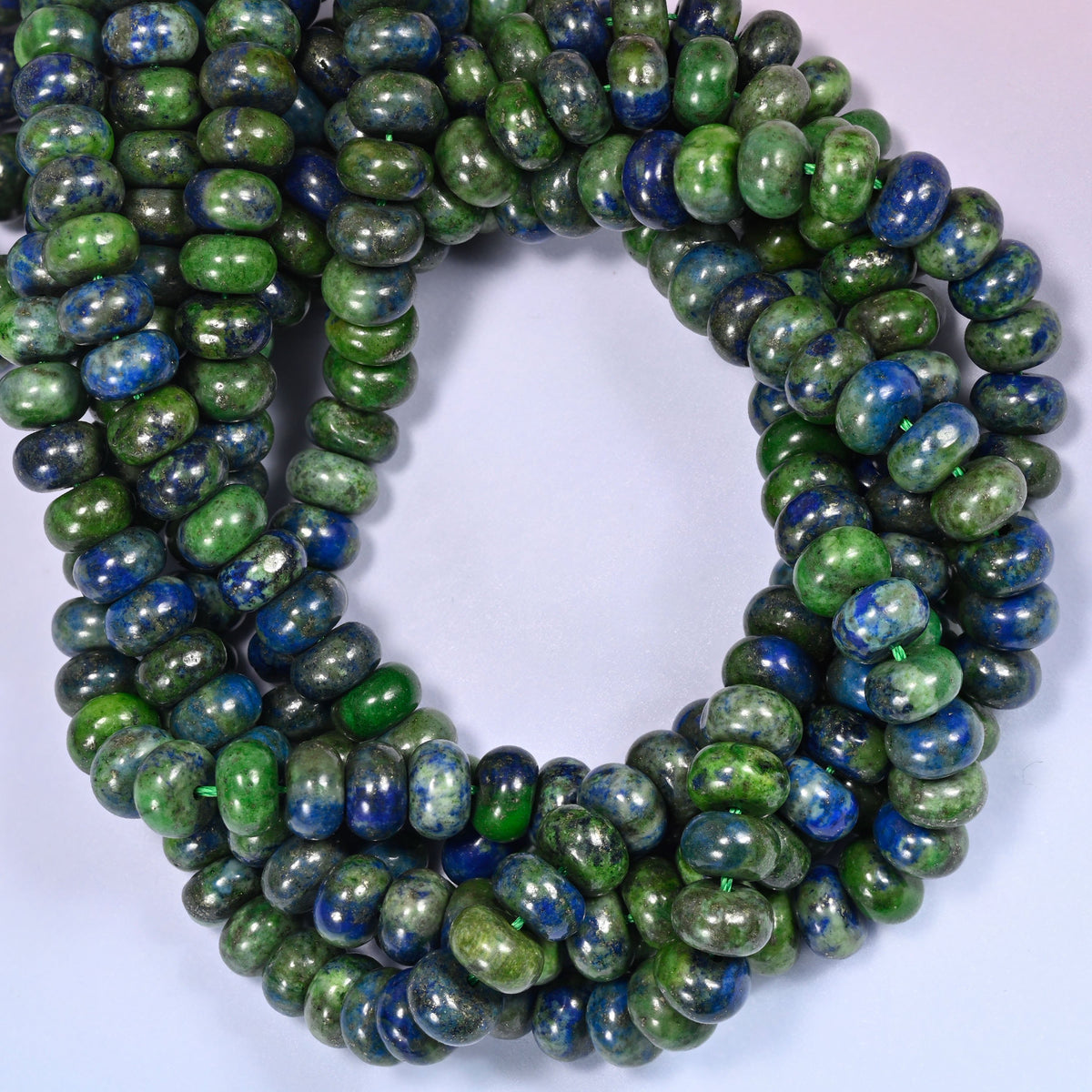 Phoenix Lapis rondelle beads, close view of the coiled strands mixing green and deep blue