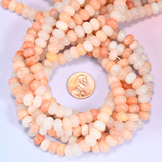 Pink Aventurine rondelle bead strands coiled around a US penny for size reference