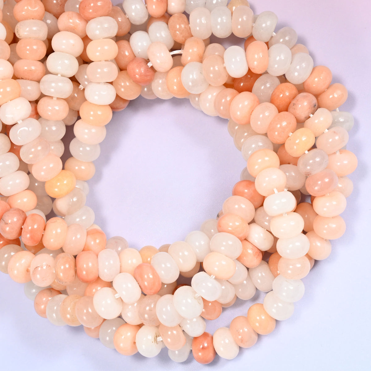 Pink Aventurine rondelle beads, close view of the coiled strands showing soft peach pink and cream