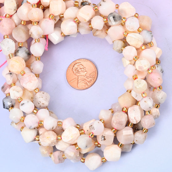 Pink Opal faceted spiral twist bead strands coiled around a US penny for size reference