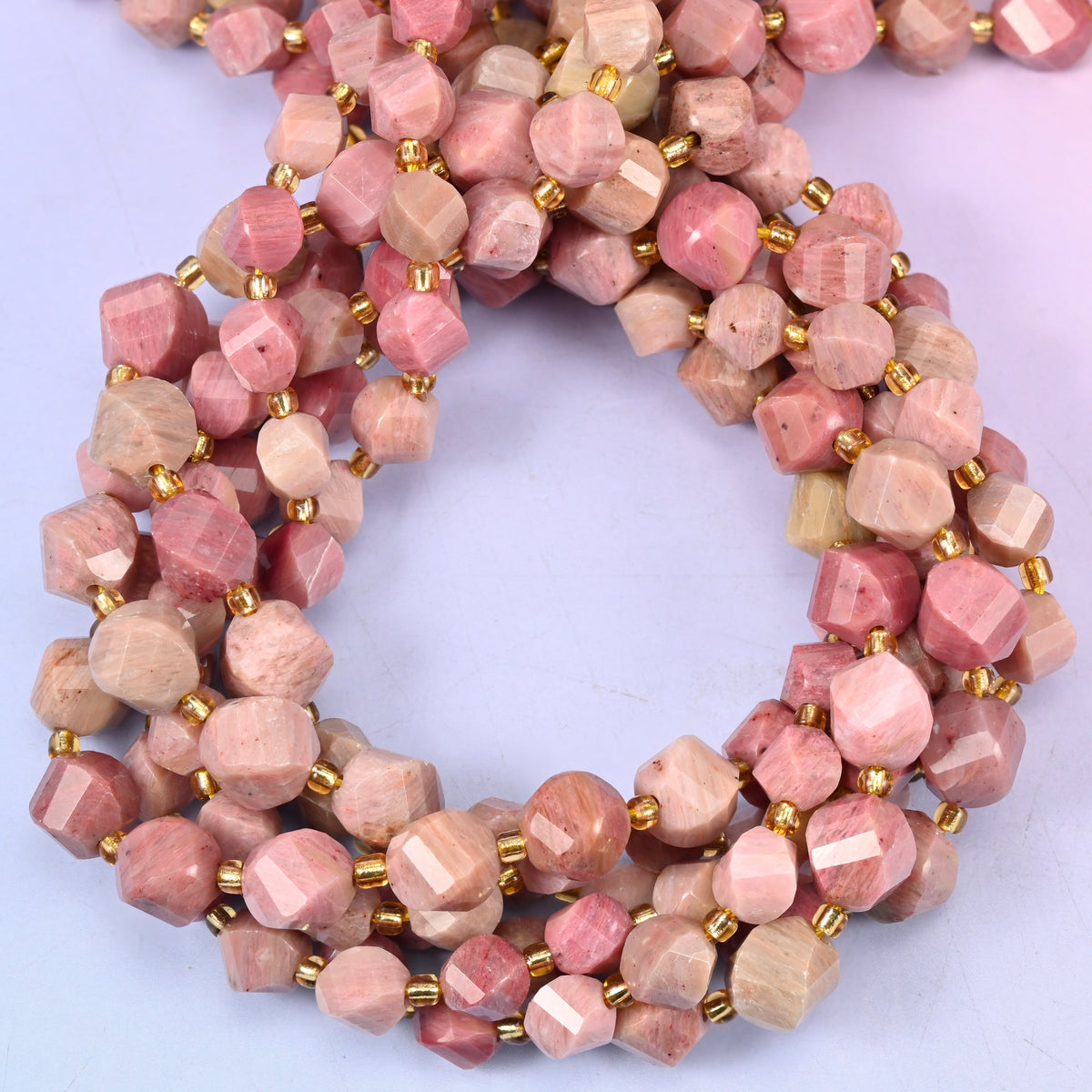 Pink Rhodonite faceted spiral twist beads, close view of the coiled strands showing dusty pink with tan and grey markings
