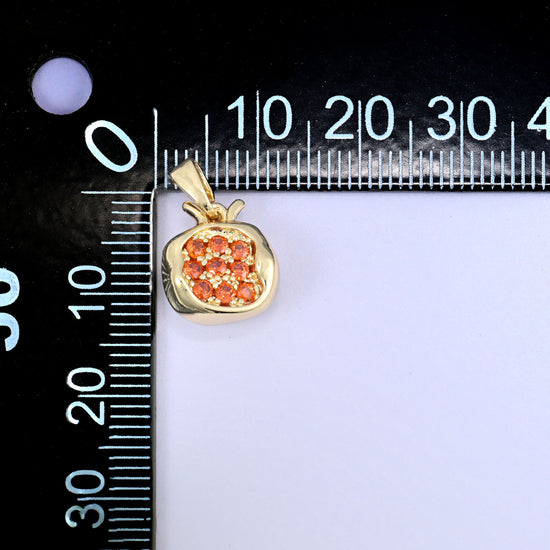 A pomegranate zircon charm photographed beside a millimetre ruler for scale