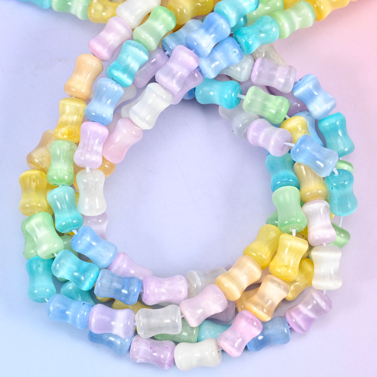Rainbow Selenite bamboo stem tube beads, close view of the coiled strands mixing pastel yellow, green, blue, lilac and white