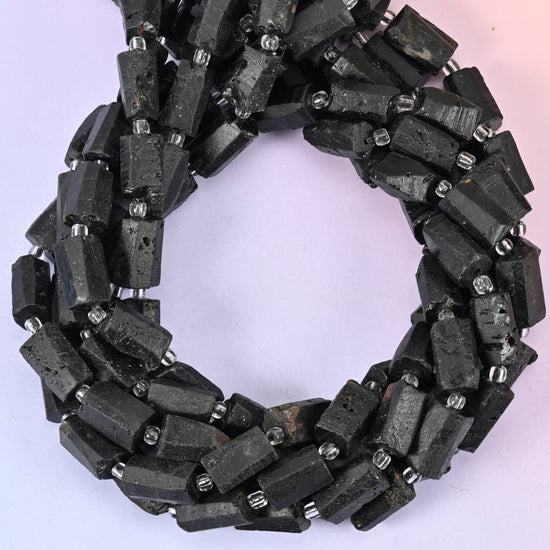 Raw Black Tourmaline faceted tube beads, close view of the coiled strands showing matte black with silver spacers