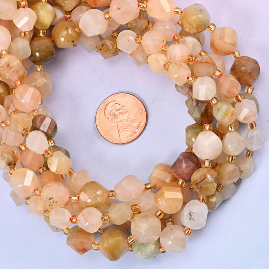 Red Grass Silk Stone faceted spiral twist bead strands coiled around a US penny for size reference