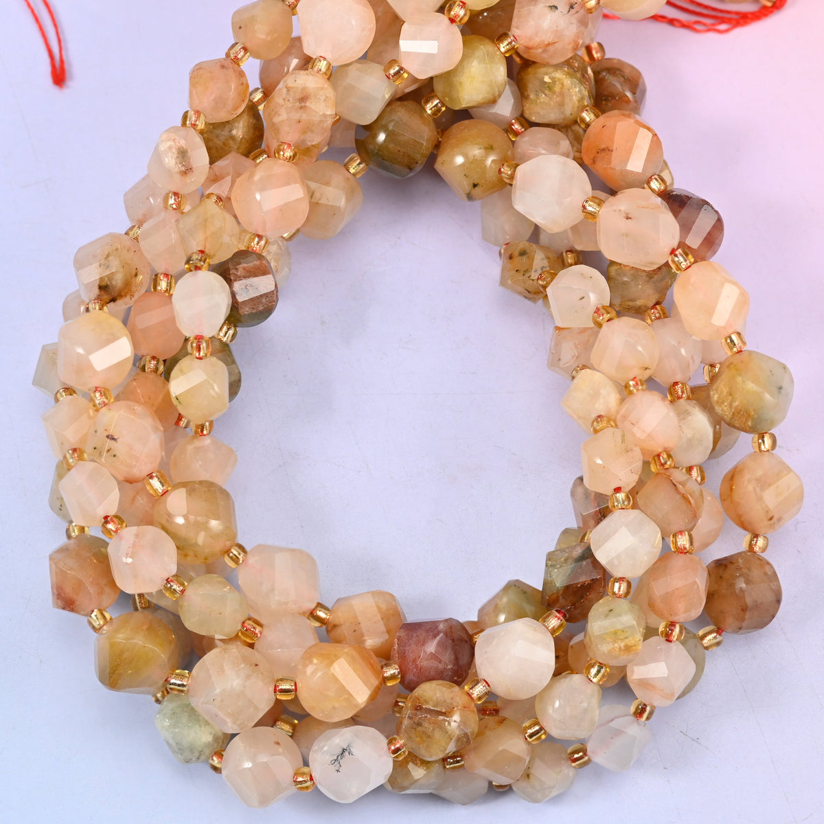 Red Grass Silk Stone faceted spiral twist beads, close view of the coiled strands mixing cream, peach and honey brown