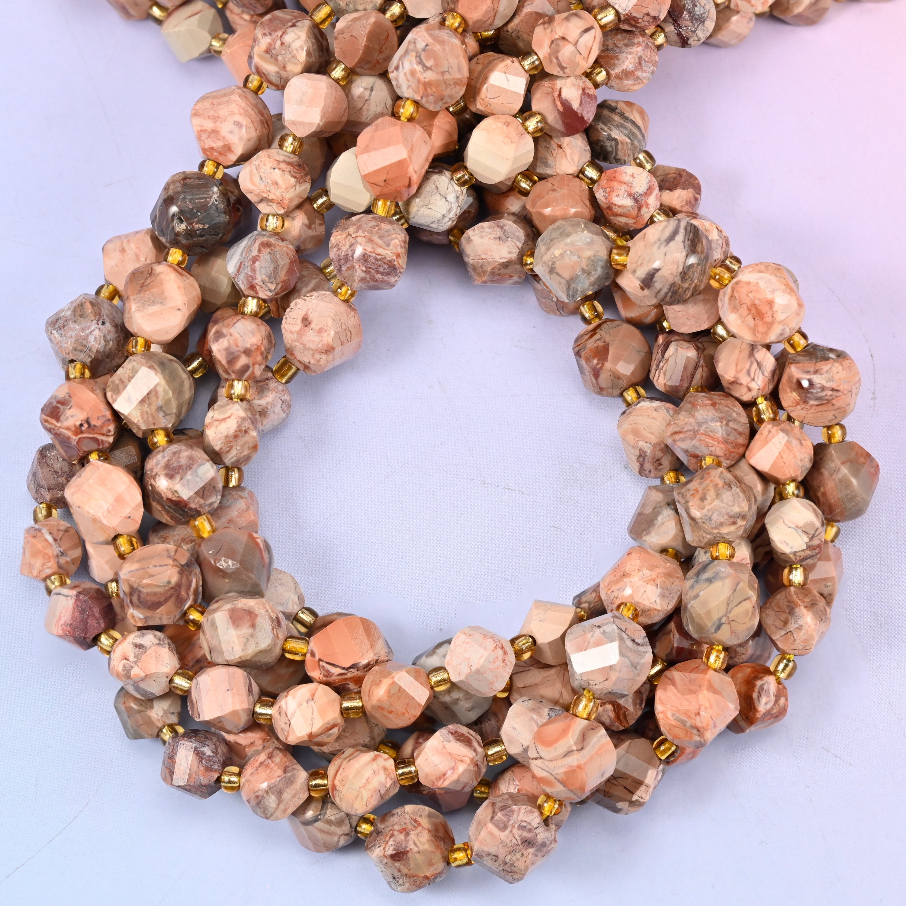 Natural Red Howlite faceted spiral twist beads, close view of the coiled strands in mottled salmon red, cream and tan