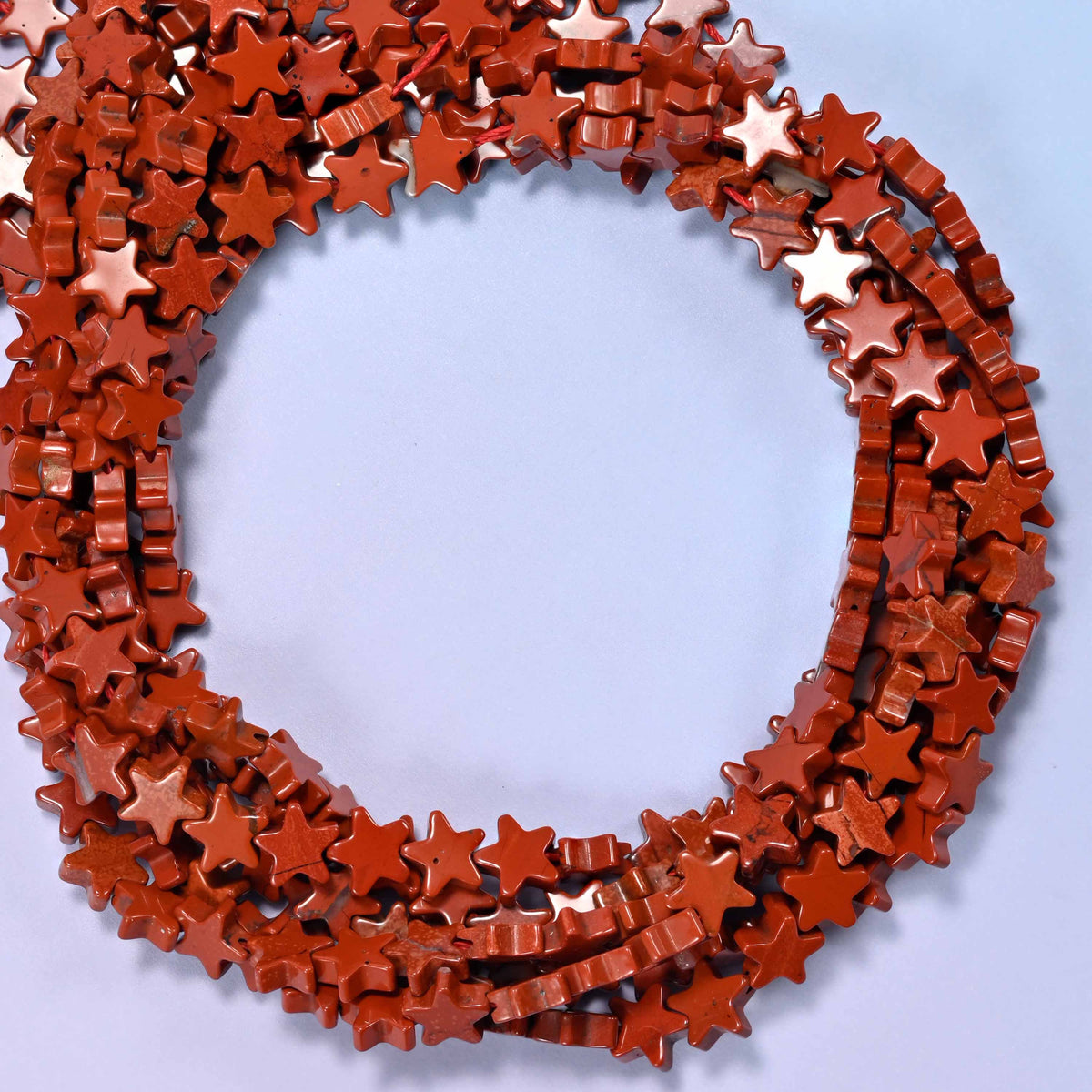 Red Jasper flat star beads, close view of the coiled strands in brick red