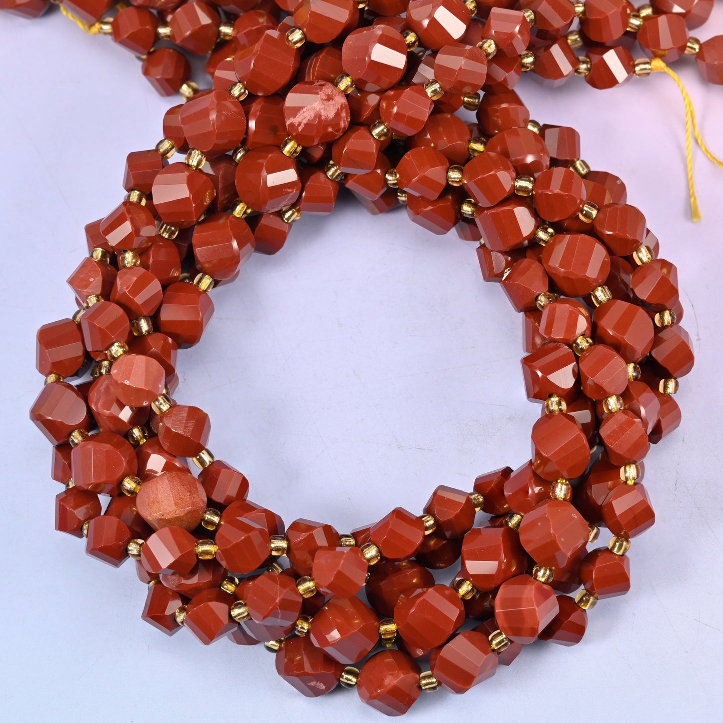 Red Jasper faceted spiral twist beads, close view of the coiled strands showing the even brick-red colour