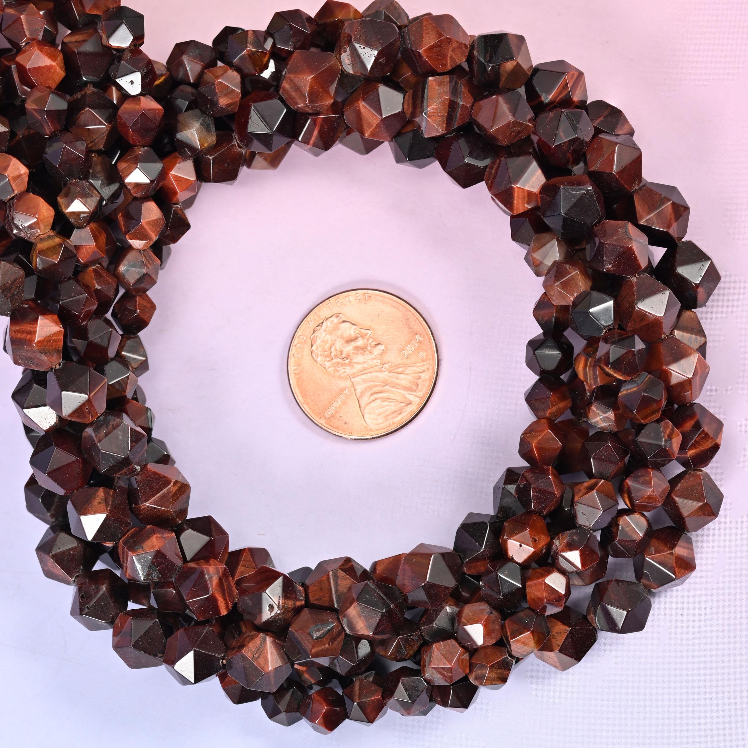 Red tiger eye faceted diamond star cut bead strands coiled around a US penny for size reference