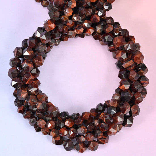 Red tiger eye faceted diamond star cut beads, strands coiled into a ring showing the deep red-brown chatoyant banding