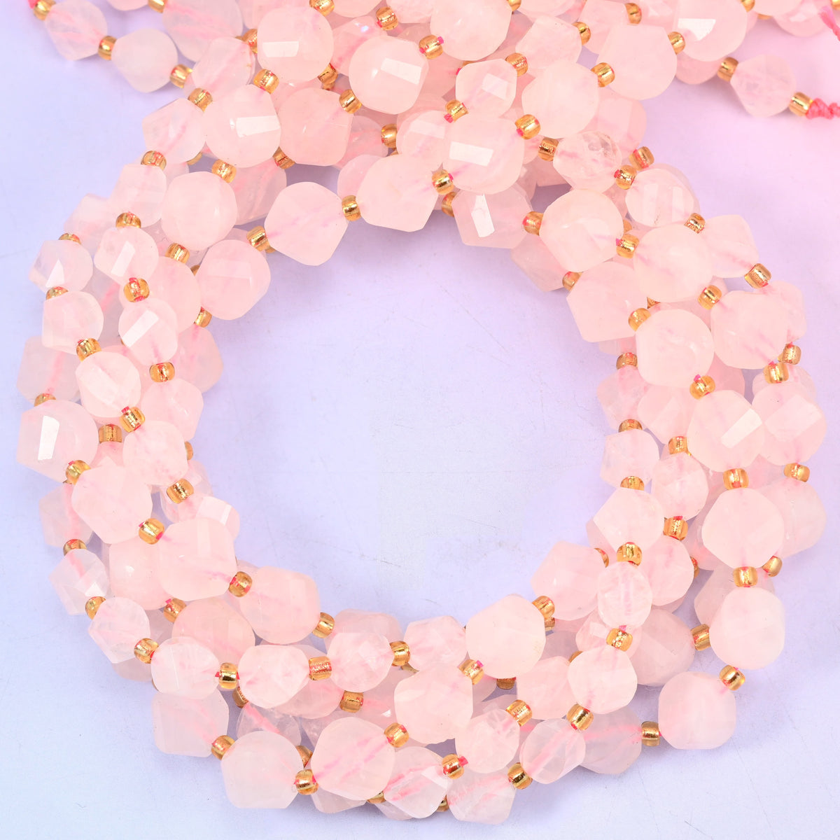 Rose Quartz faceted spiral twist beads, close view of the coiled strands showing the soft pink colour